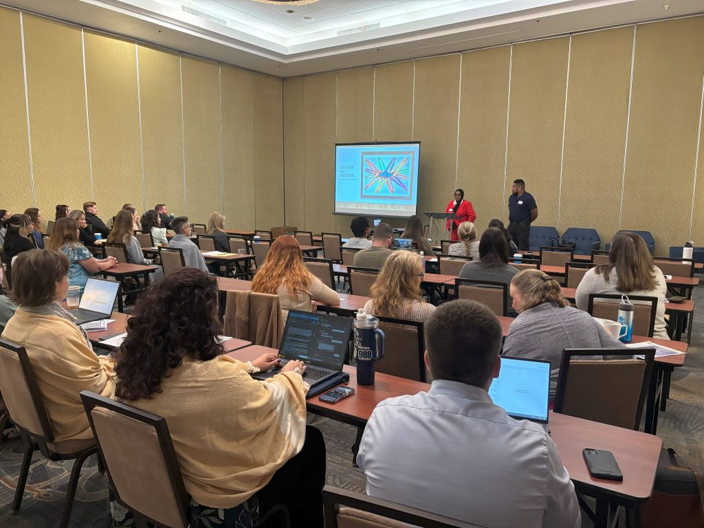 Public Defenders sitting in a conference room and listening to a presentation.